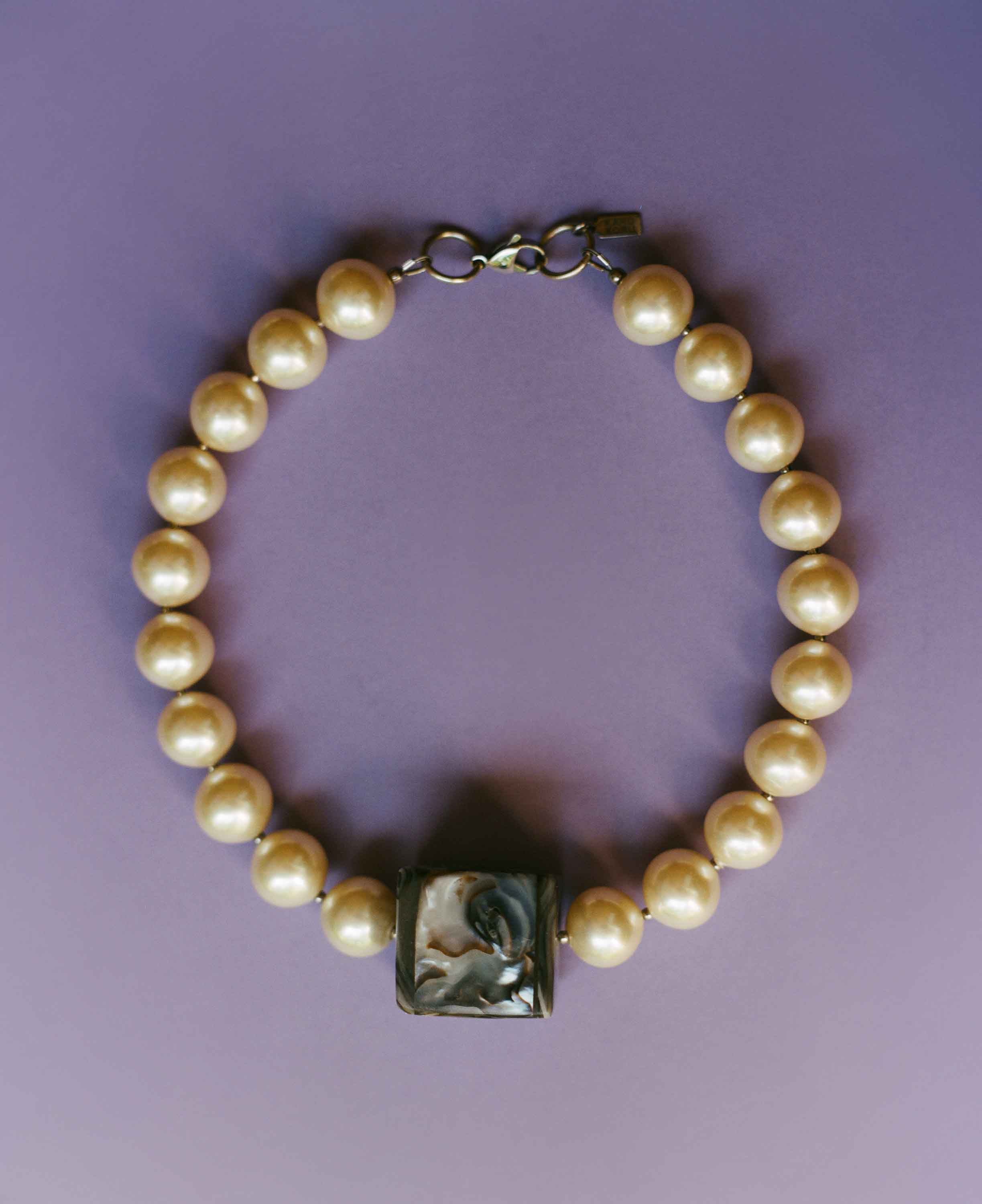 Pearl bracelet with a square clasp on a purple background