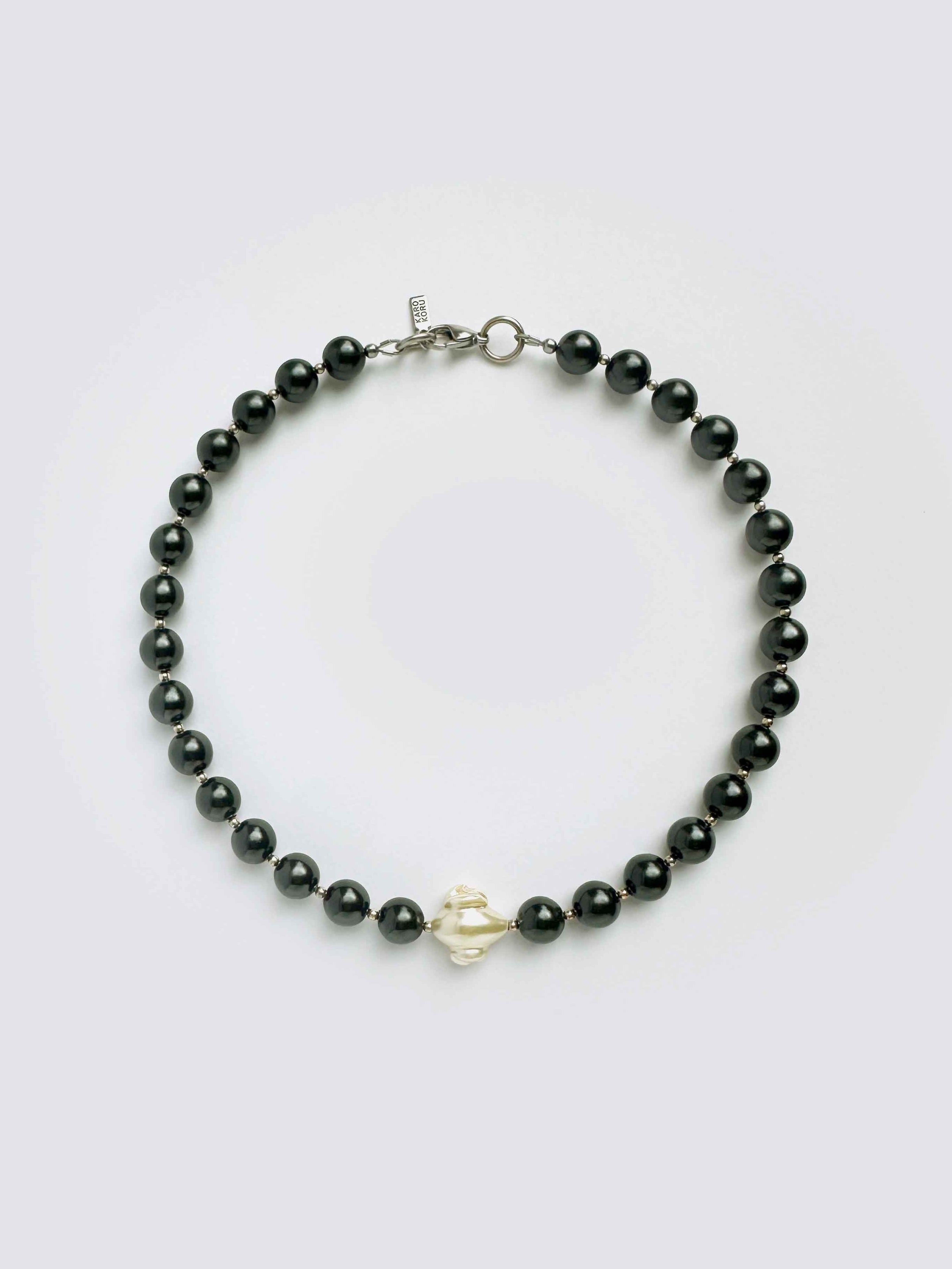 Black beaded bracelet with a gold clasp on a white background