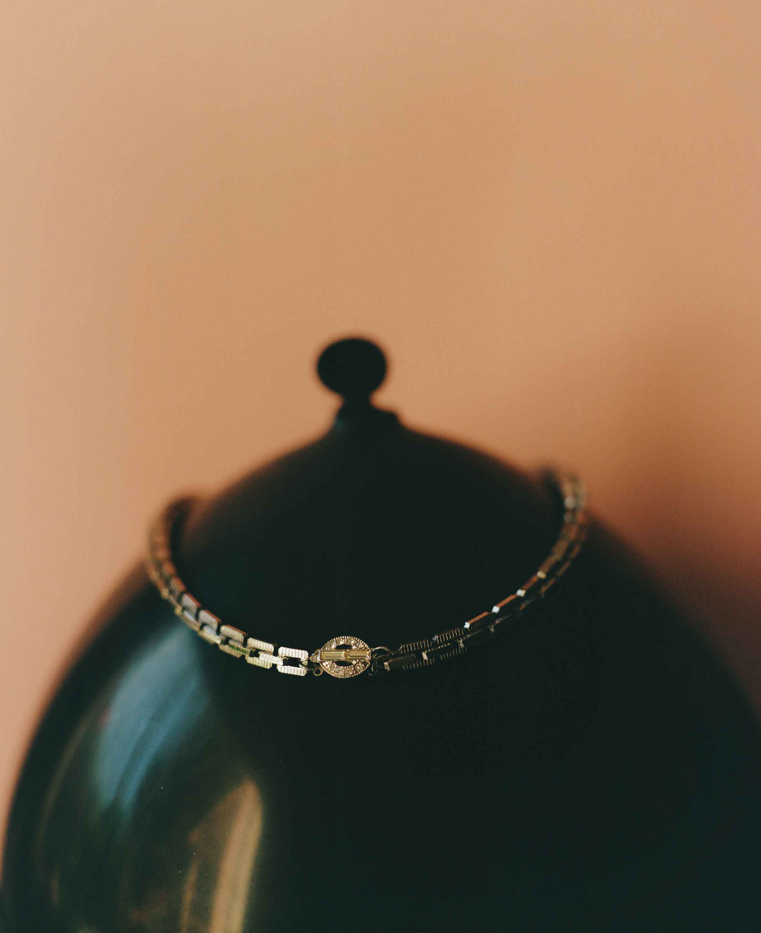 Bracelet on a black stand with a blurred beige background