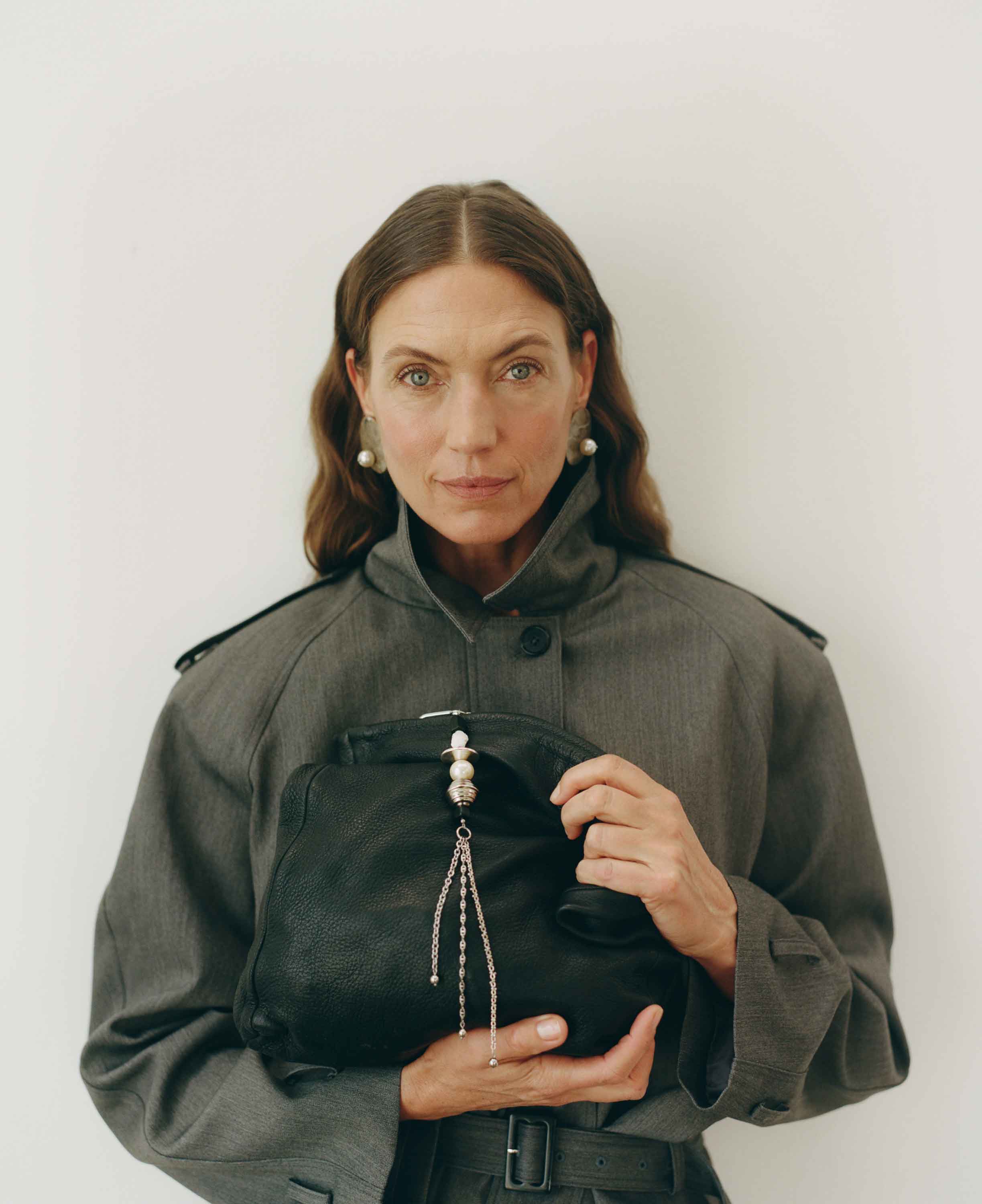 Woman holding a black bag against a white background