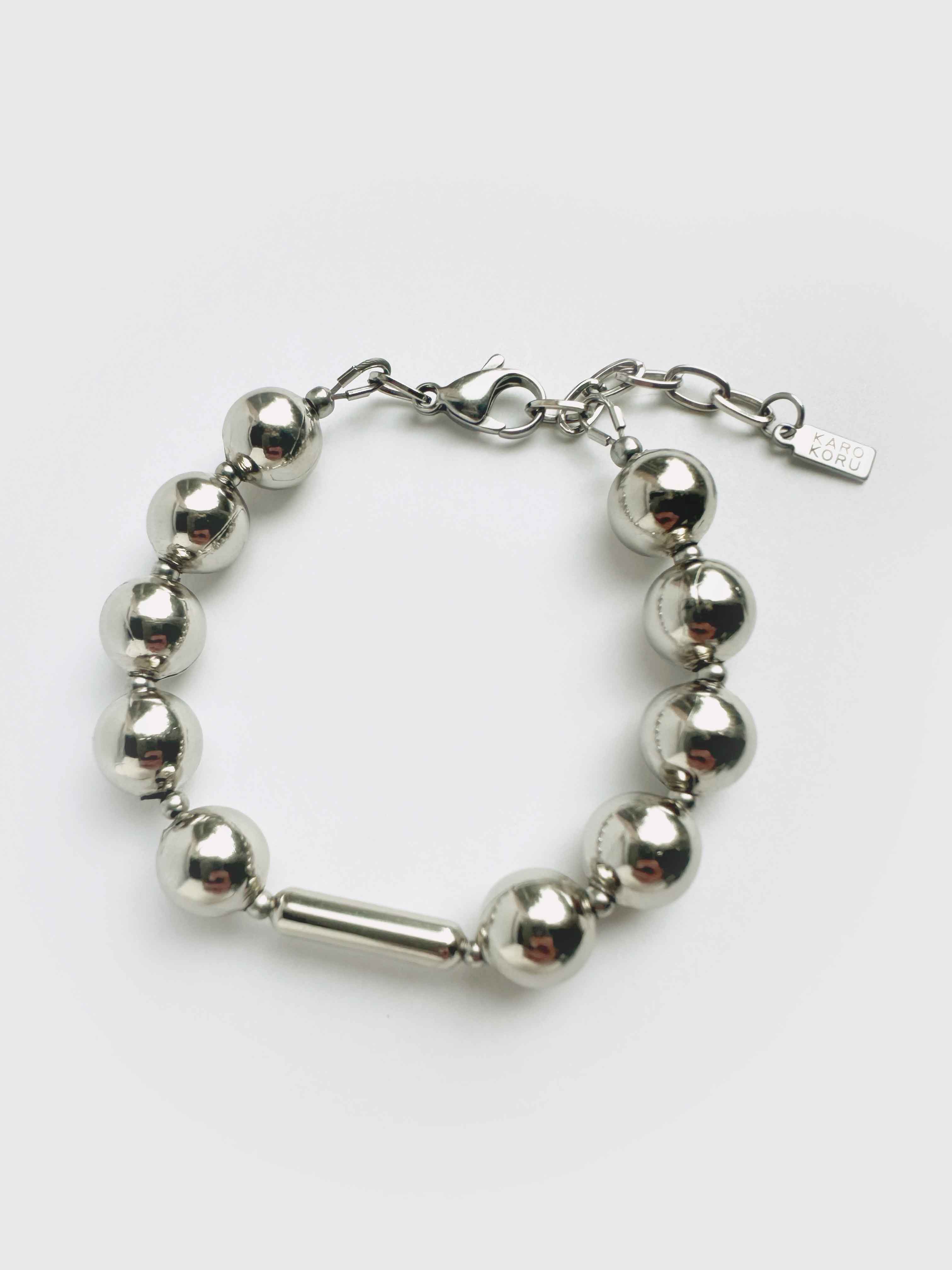 Silver bracelet with round beads on a white background