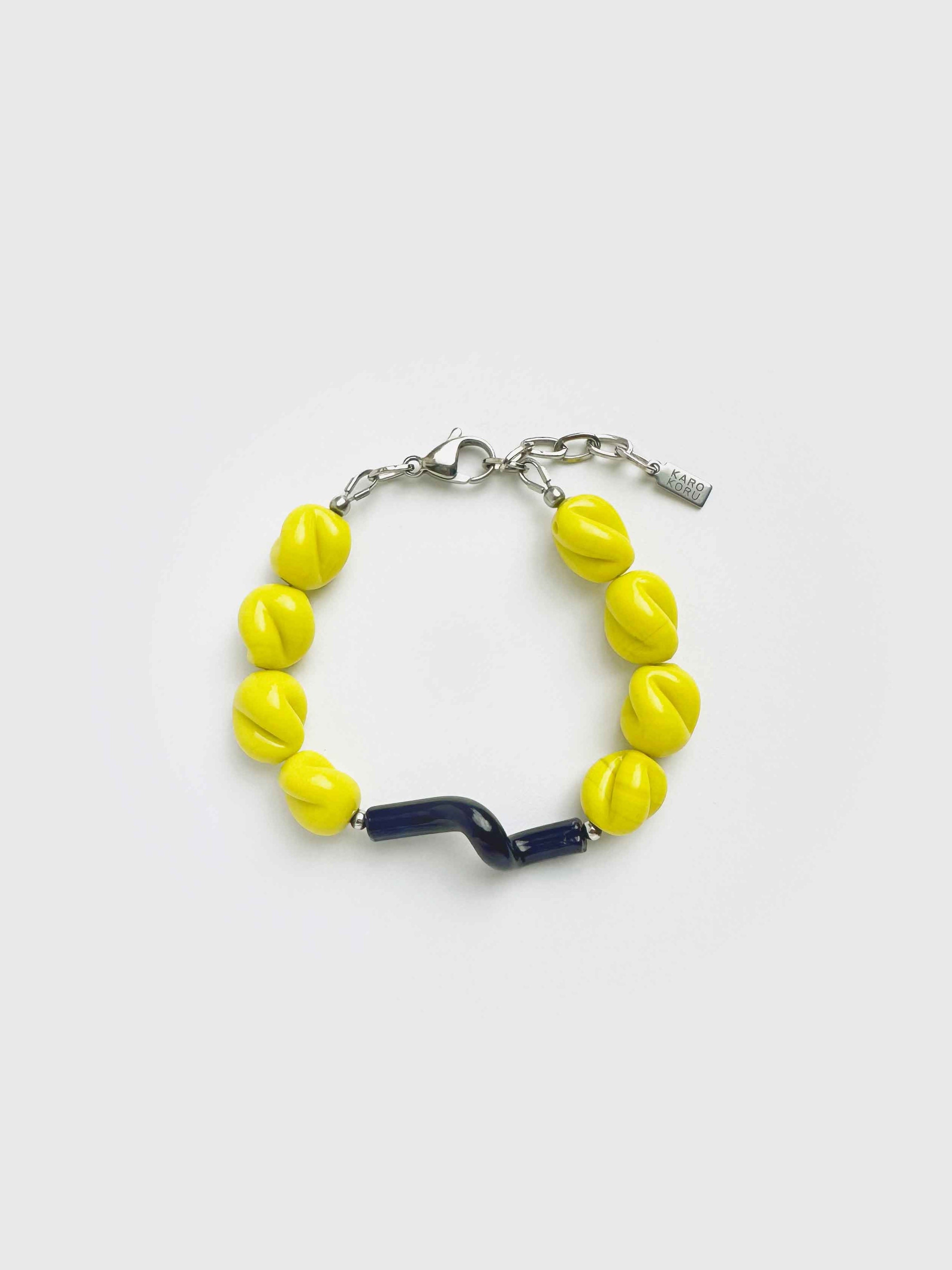 Bracelet with yellow beads and a blue accent on a white background