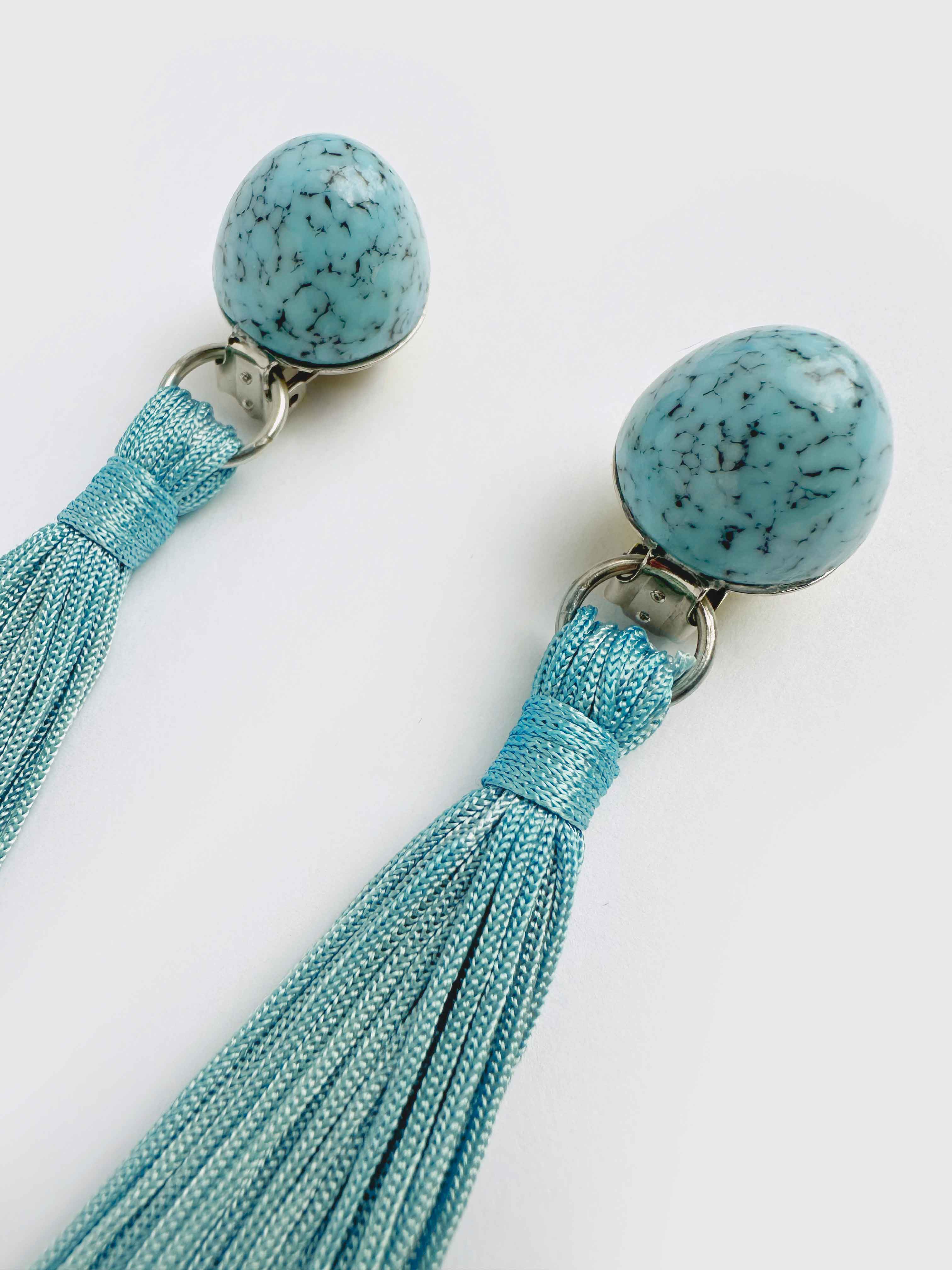 Turquoise tassel earrings with bead tops on a white background