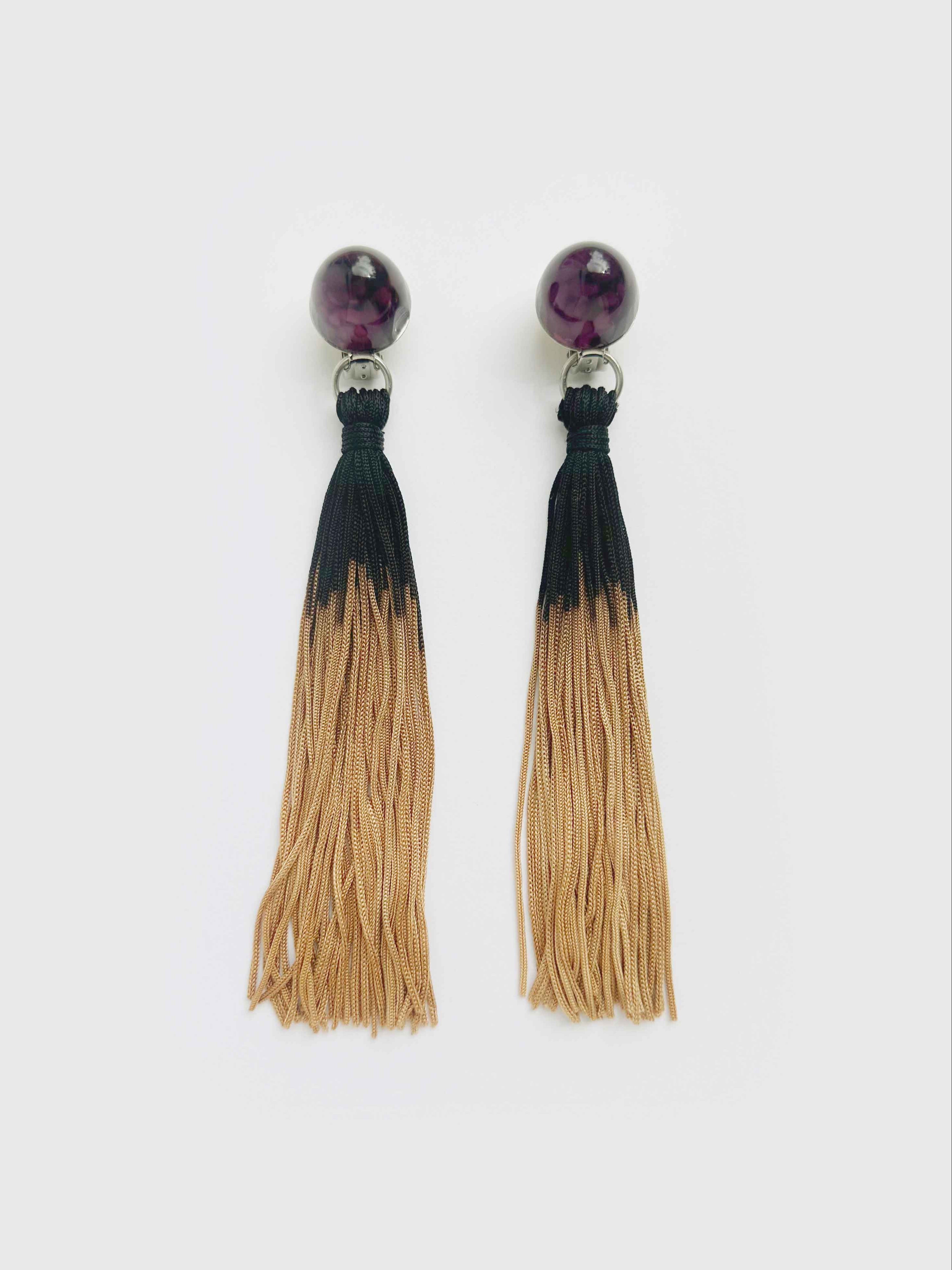 Pair of tassel earrings with black and beige gradient on a white background
