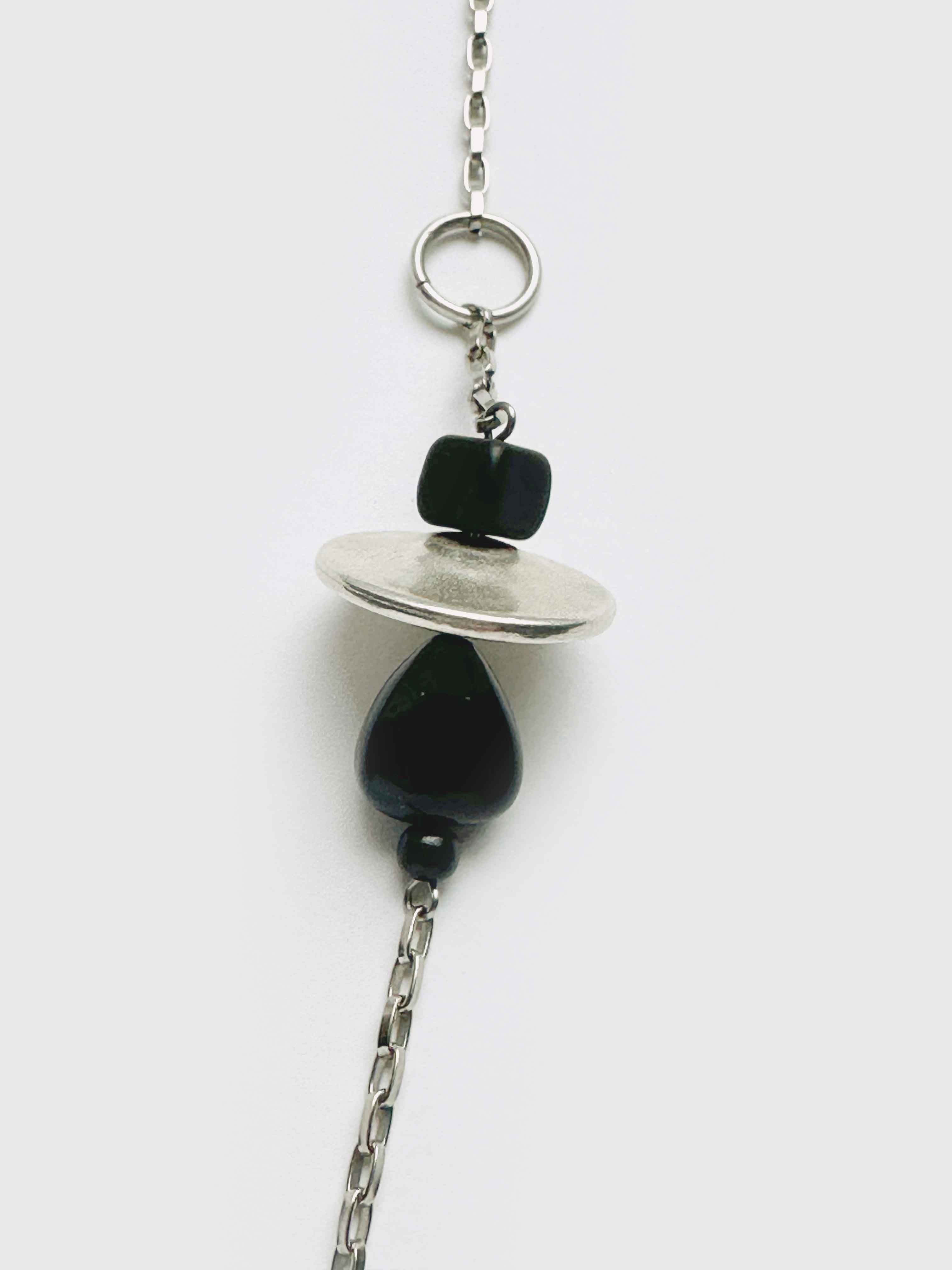 Necklace with black beads and silver chain on a white background