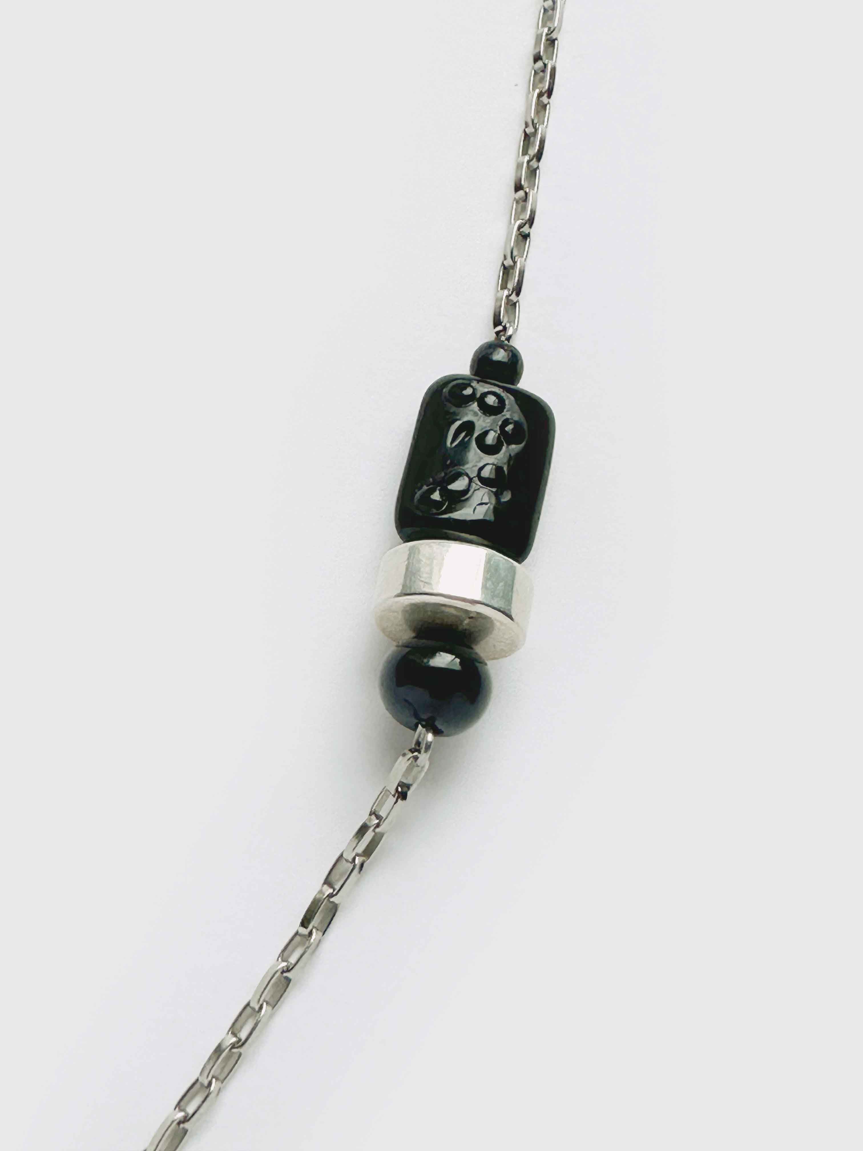 Necklace with black and silver pendant on a white background